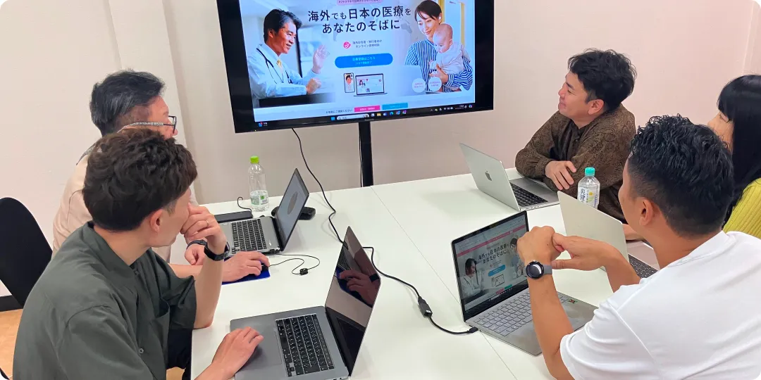 男性4人が会議をしている